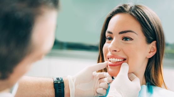 Dentista aplicando tratamiento dental a una mujer